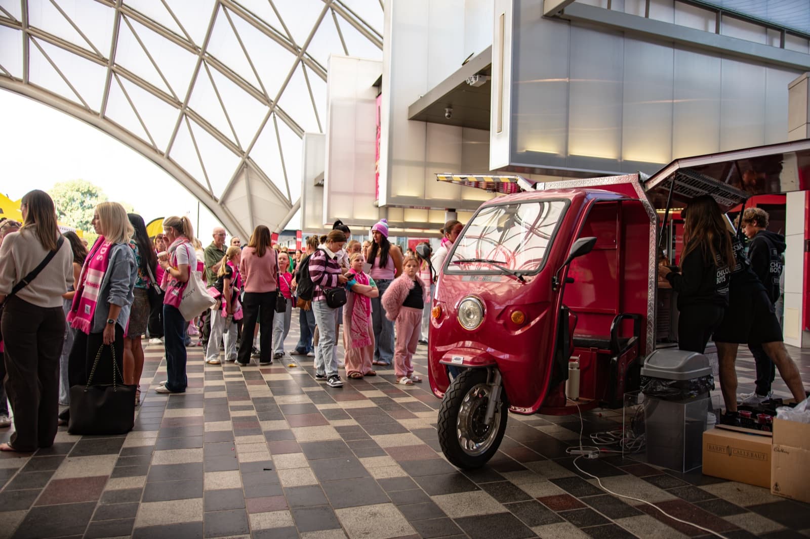 Pink-dressed crowd alongside the Chocolate Boys tuk-tuk