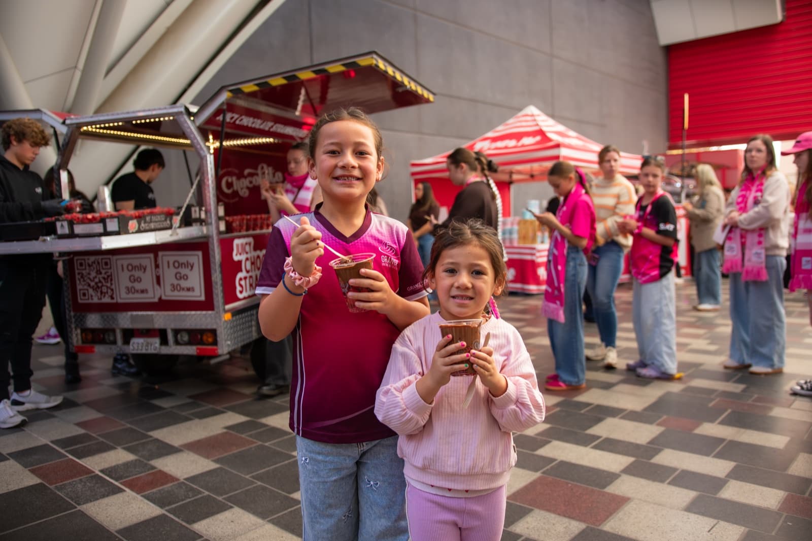 Two young kids smiling with Chocolate Boys strawberry cups