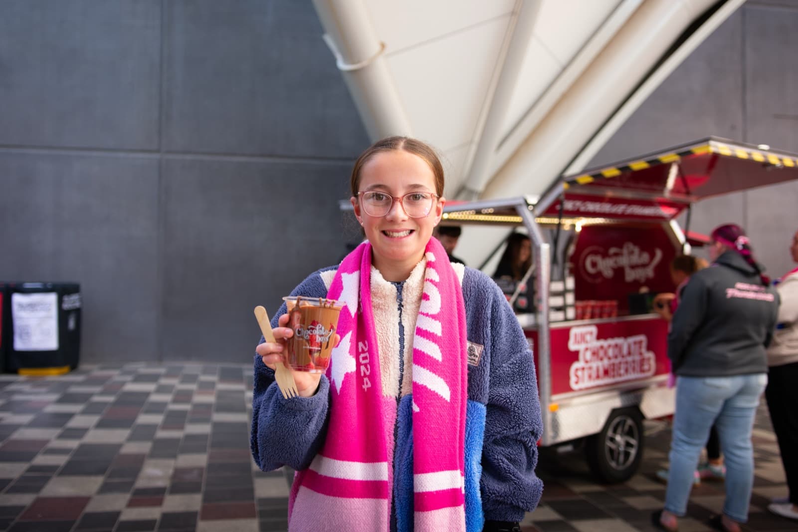 Happy customer holding a Chocolate Boys strawberry cup